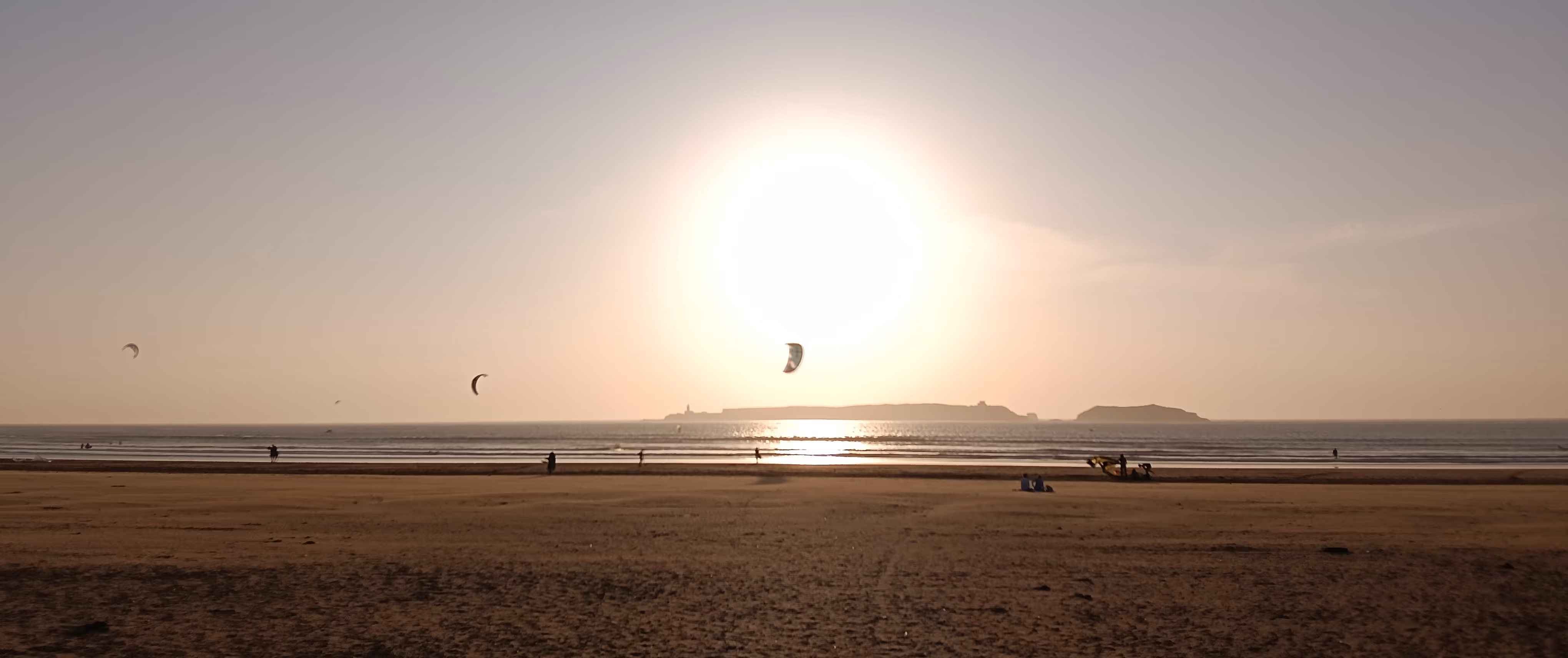 Kite surfers on Essaouira beach at golden hour