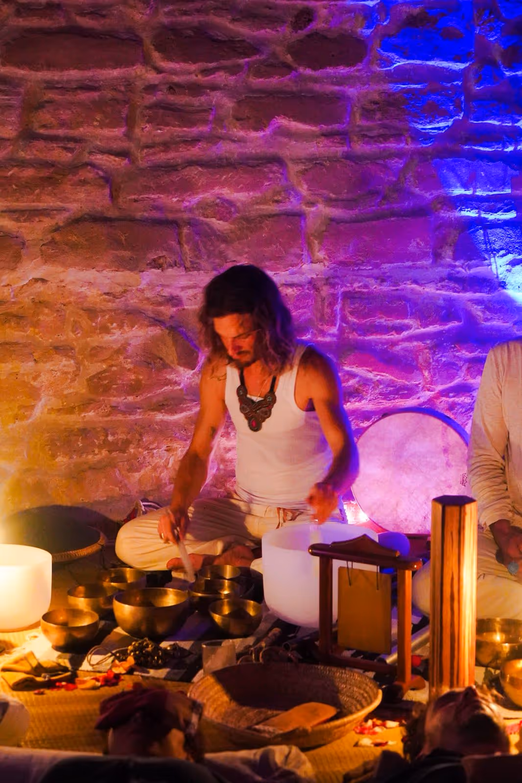 A quiet moment with Morgan seated next to a carved Moroccan cabinet, holding a singing bowl