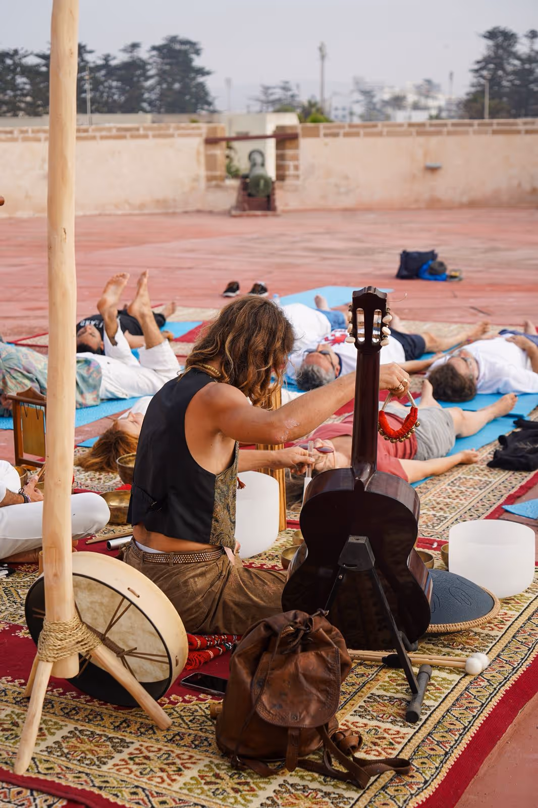 A group yoga session at sunset on a rooftop in Essaouira, led by Morgan